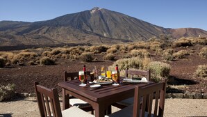 Une table dressée à l’extérieur, avec une montagne en arrière-plan.