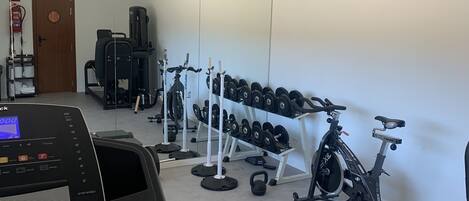 Et fitnesscenter med løbebånd, træningsmaskiner og vægtløftningsområde.