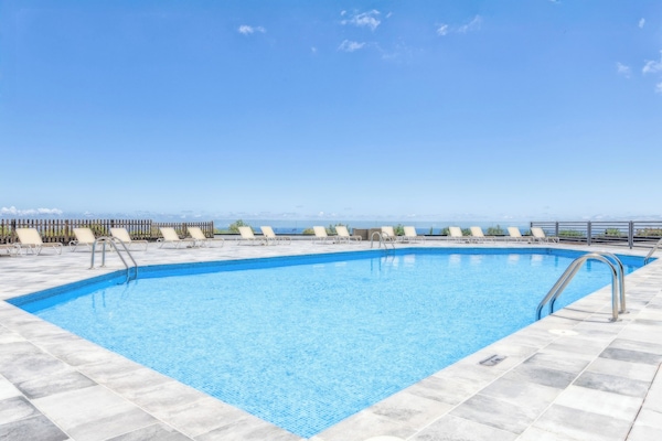 Alberca al aire libre, sombrillas en la alberca y camastros