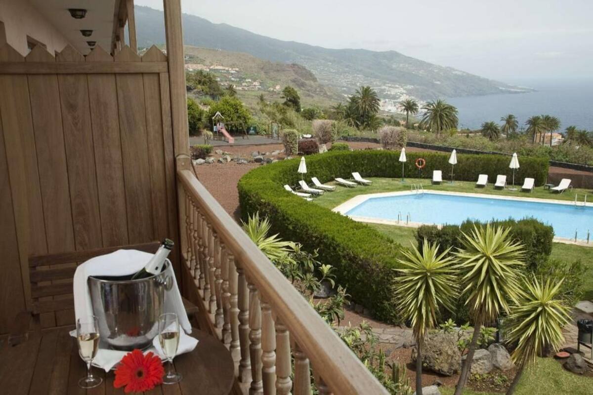 Un balcón con piscina, sillas de descanso y vistas al mar.