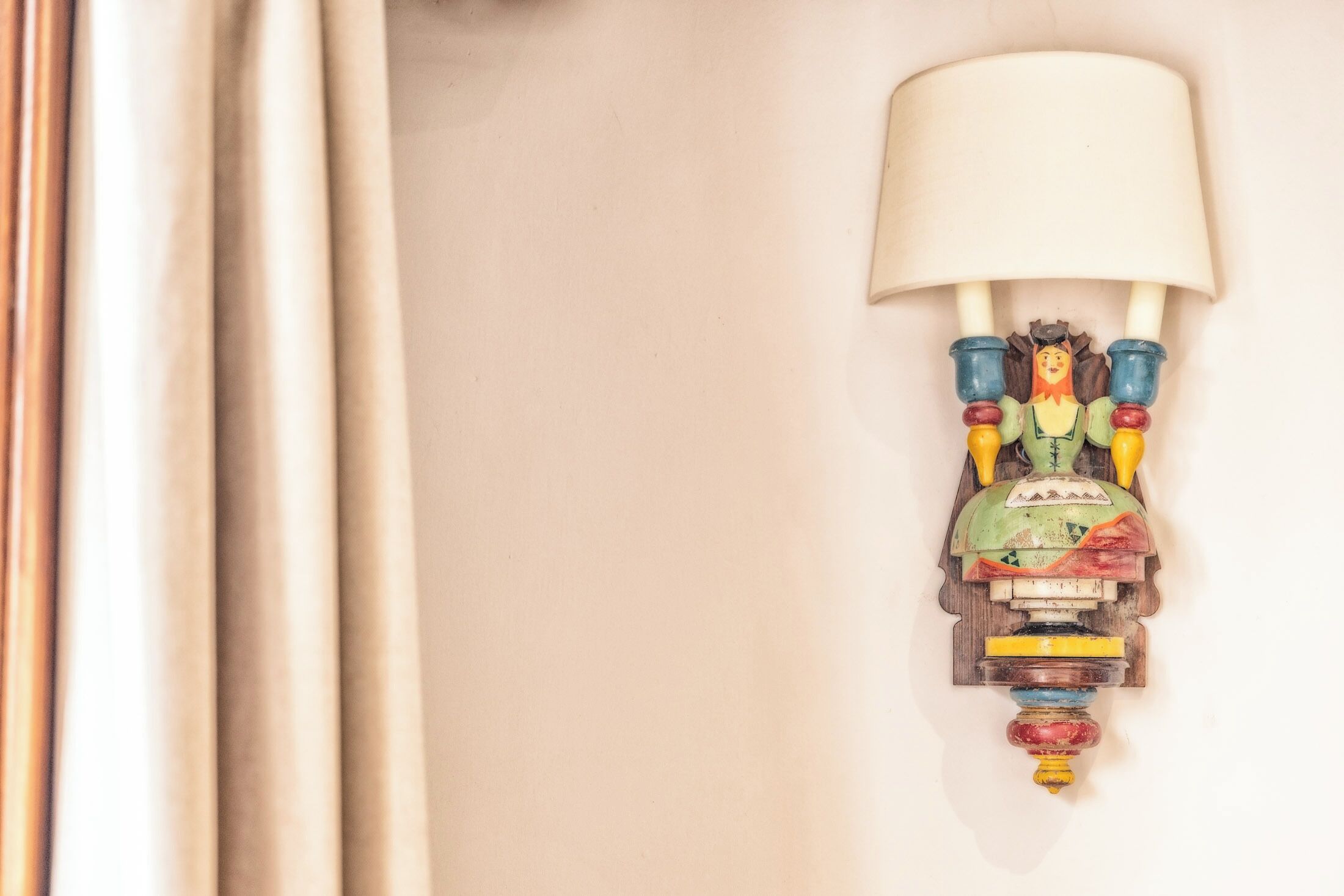 Una lámpara de pared con un diseño único, que presenta una figura y varios elementos de colores.