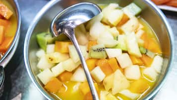 A bowl of fruit salad with a spoon.