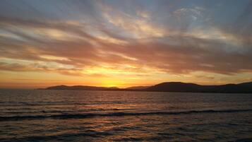 In Strandnähe, weißer Sandstrand, Sonnenschirme, Strandtücher