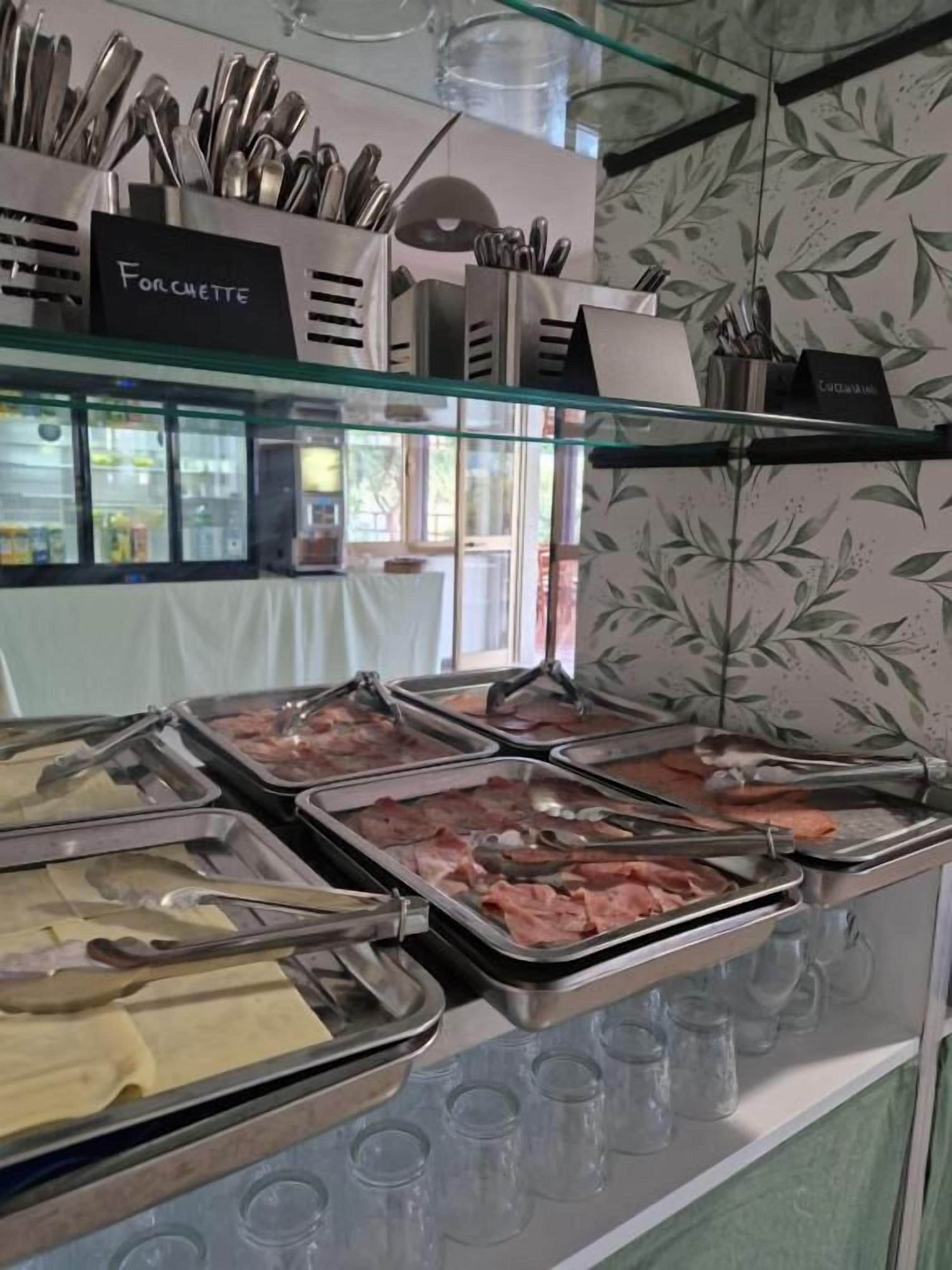 A buffet with various food items and utensils.