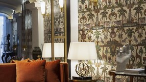 A living room with a sofa, a coffee table, and a patterned wall. - Eight Hotel Portofino (Portofino)