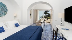 A hotel room with a bed, a desk, and a view of the outdoors. - Hotel La Vega (Capri)