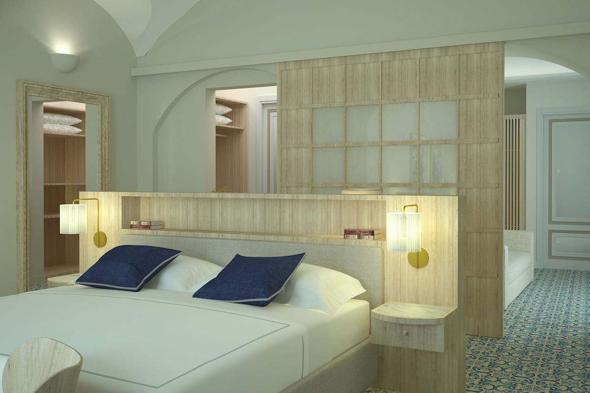 A bedroom with a large bed, two bedside lamps, a mirror, and a wardrobe.