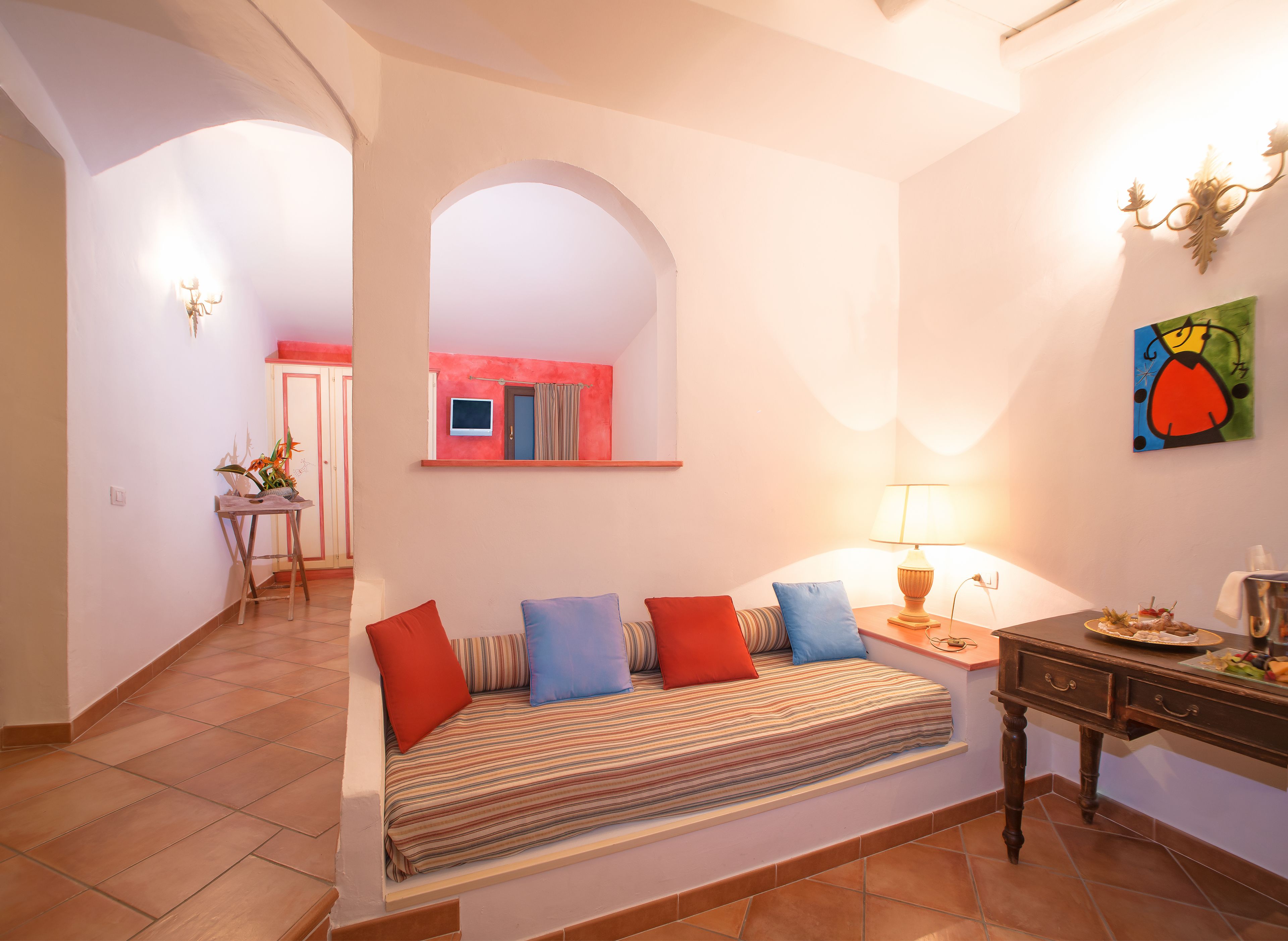 Una sala de estar acogedora con un sofá, una mesita y un televisor de pared.