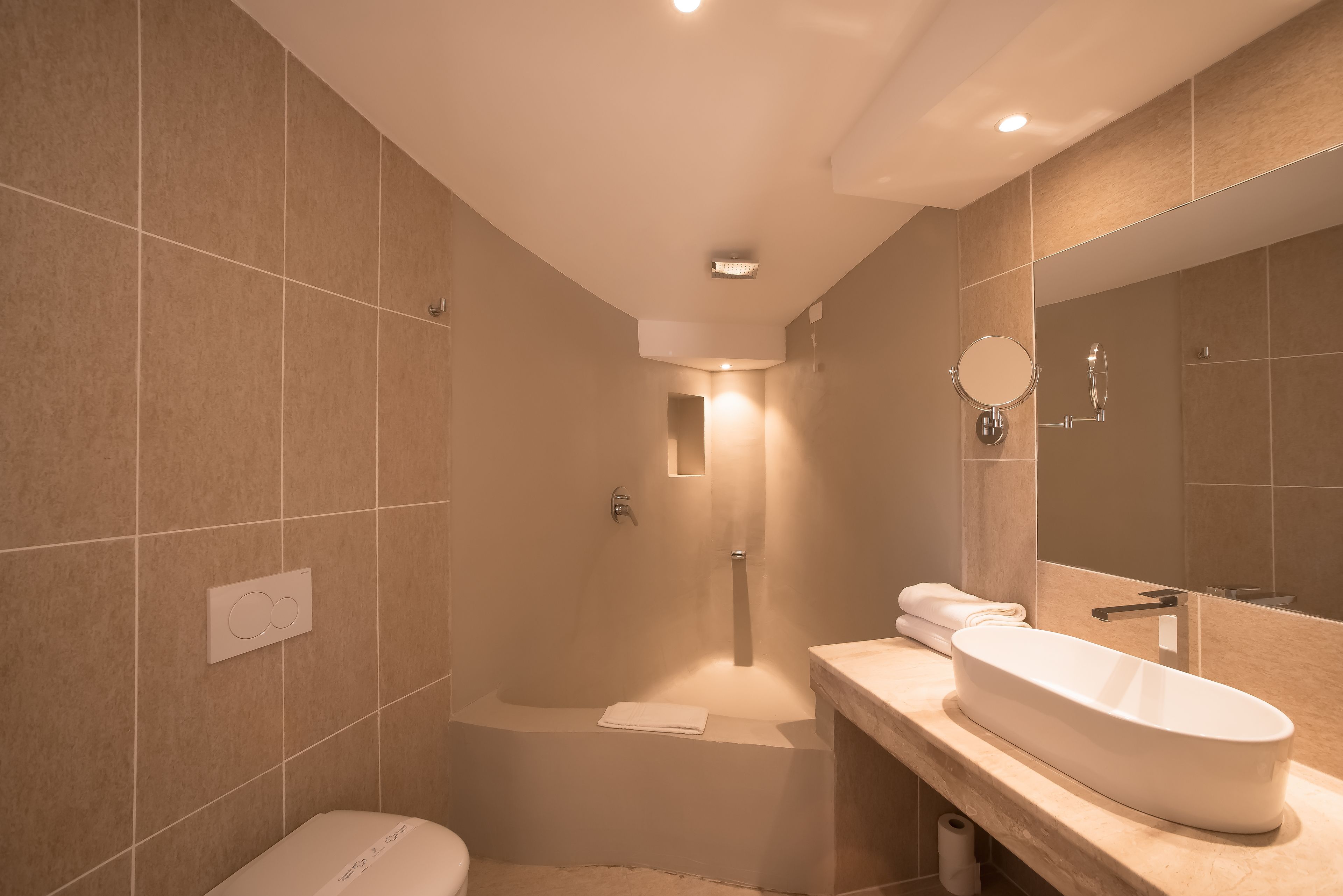A modern bathroom with a bathtub, a large mirror, and a sink.