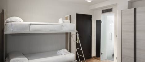 Habitación con literas, una escalera, una puerta y un armario.