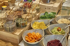 A variety of food items and ingredients displayed in bowls and jars on a wooden table. - Petit Palace Posada del Peine (Madrid)