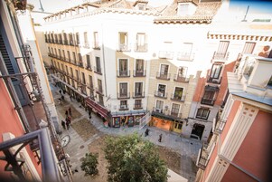 A courtyard with buildings, balconies, and a clock.