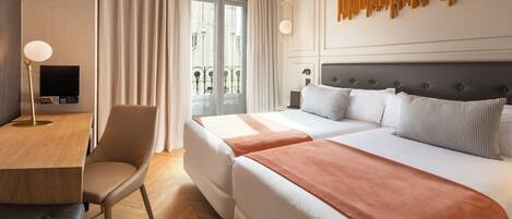A hotel room with a bed, a desk, and a chair.