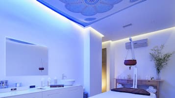 Relax in a serene space with a large bed, bench, and a bathroom featuring a sink and mirror.