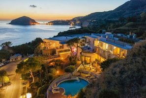 A coastal hotel with a swimming pool, outdoor seating, and a view of the sea. - Hotel San Giorgio Terme (Barano d'Ischia)