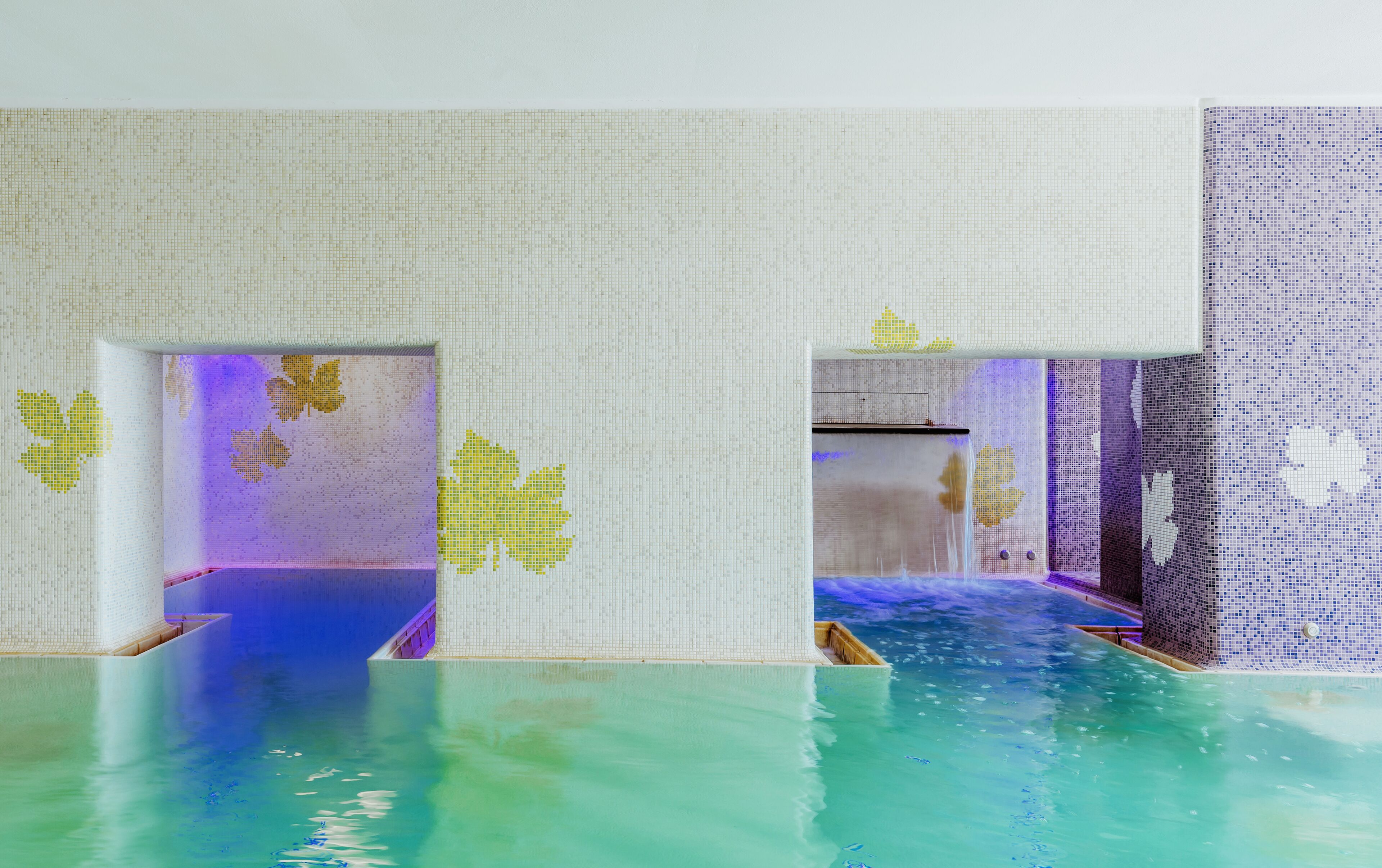 Une chambre dotée d’une grande fenêtre, d’un lit et donnant sur une piscine.