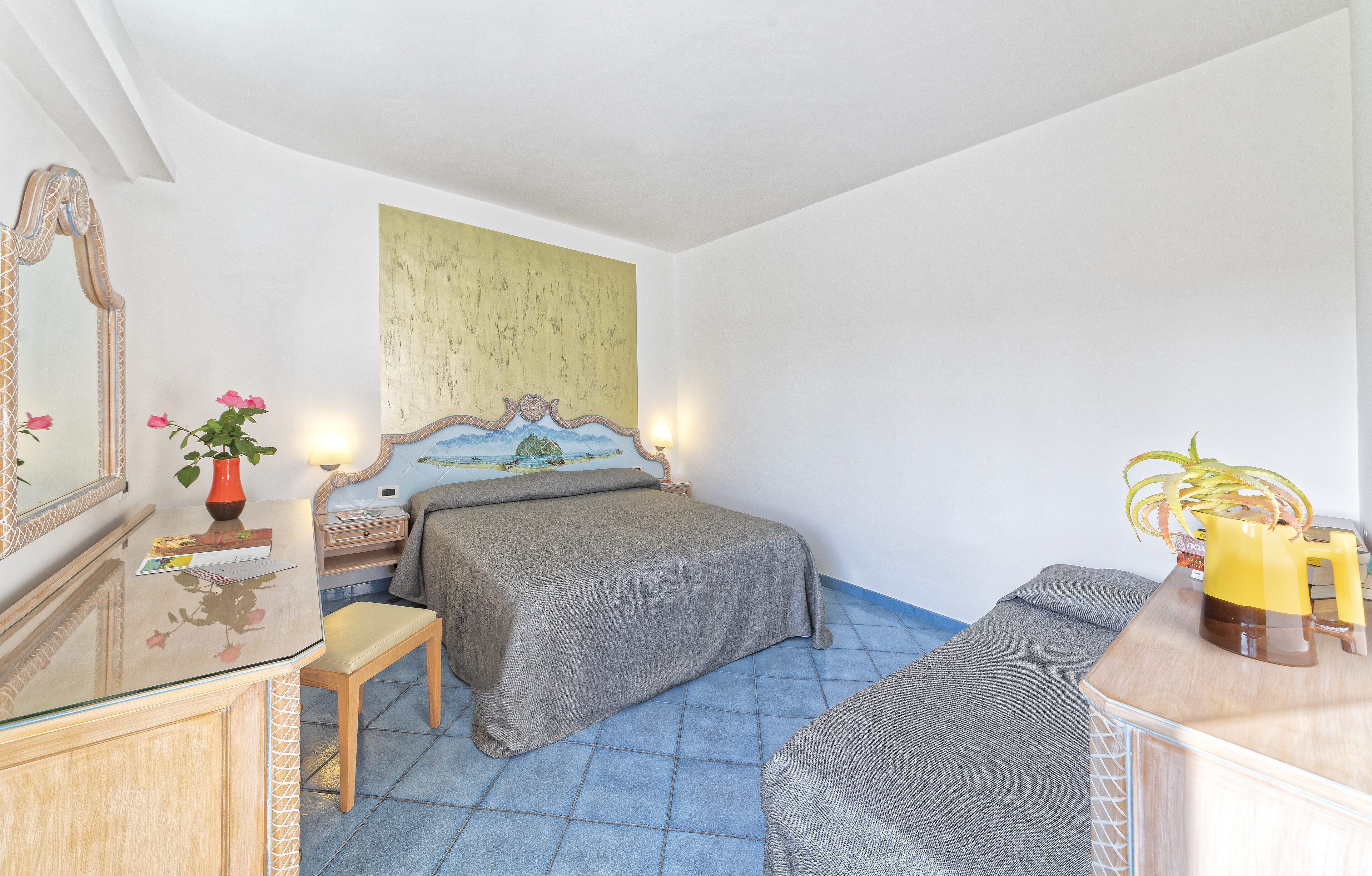 Ein Schlafzimmer mit Bett, Nachttisch und Spiegel.