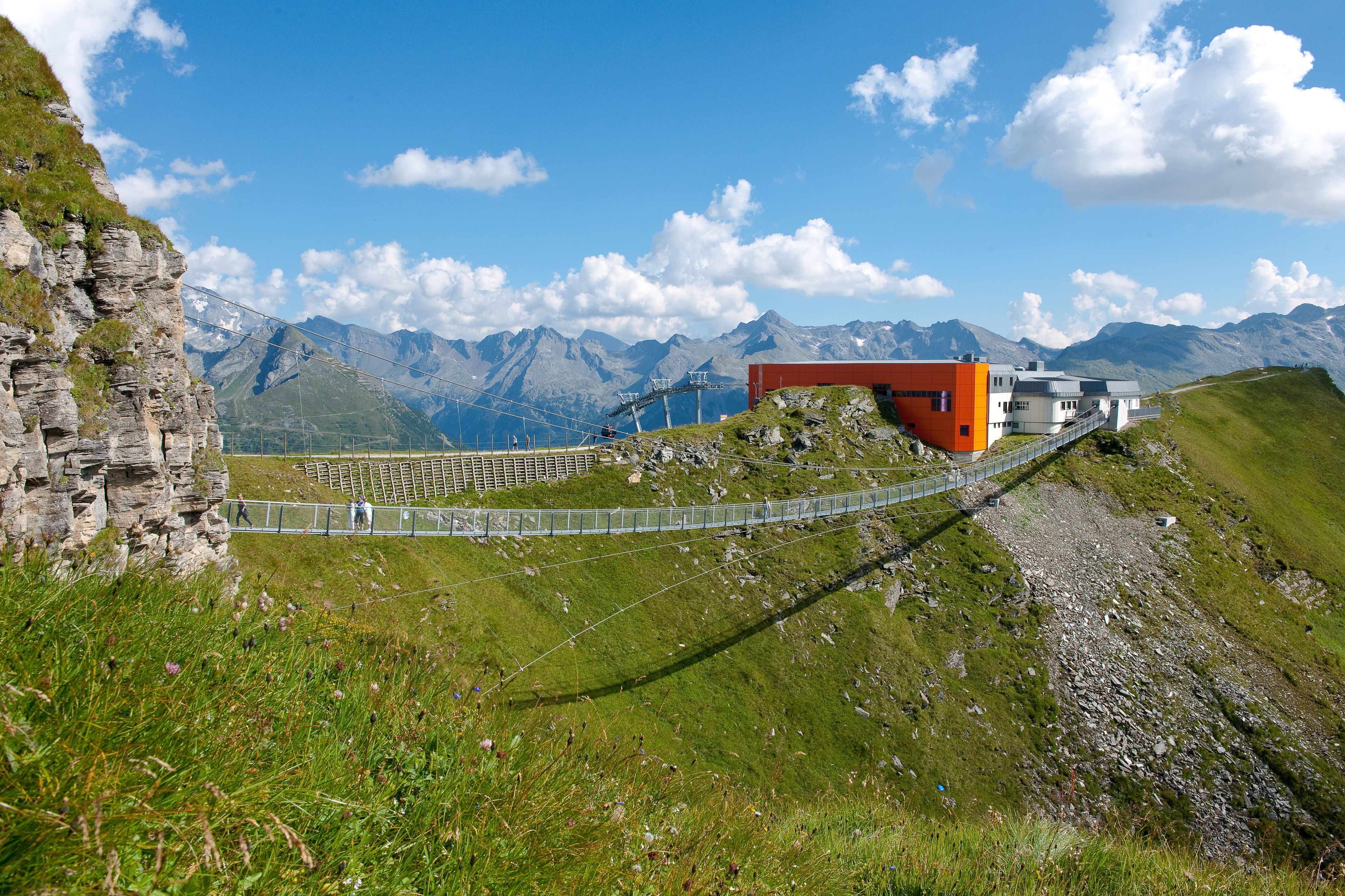 A mountain lodge with a ski lift, surrounded by rocky terrain and alpine views.