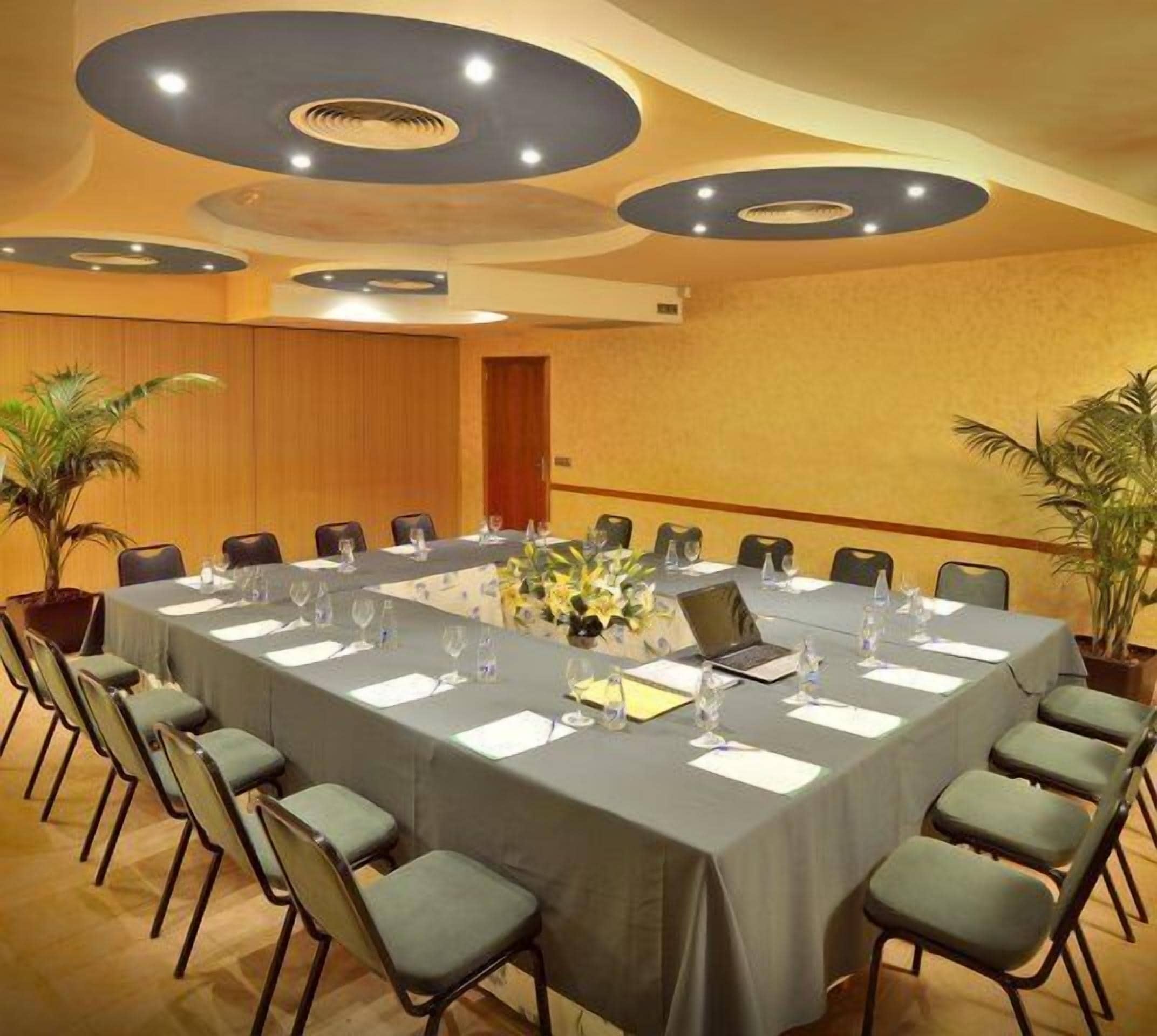 A conference room with a long table, chairs, and a laptop.