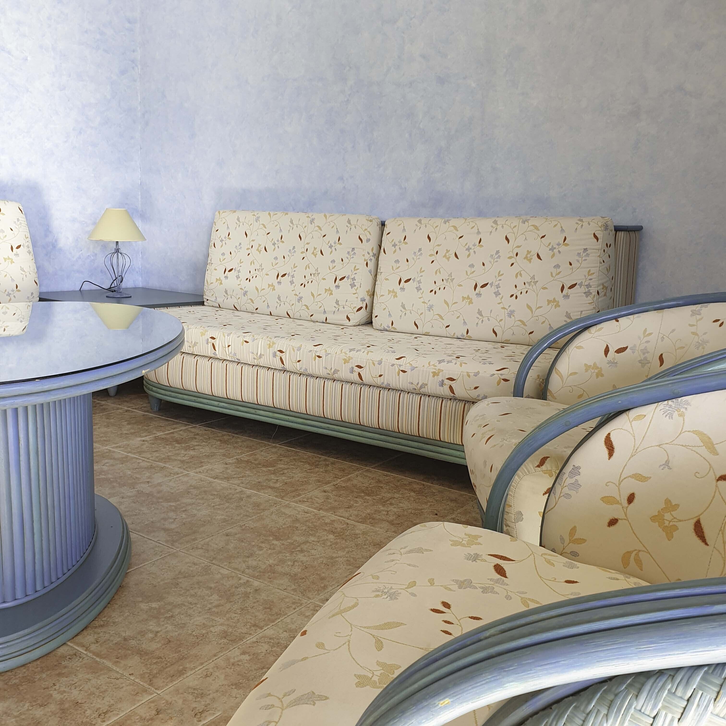 A living room with a sofa, a round coffee table, and a lamp.