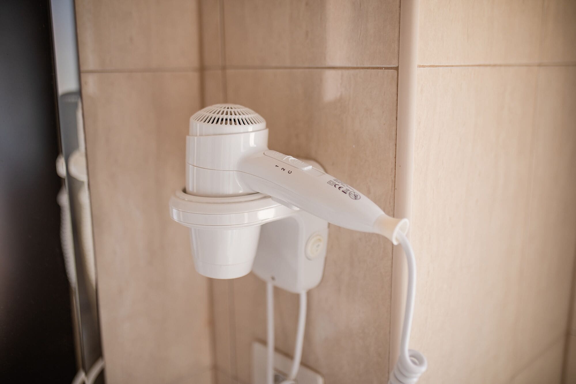 A hair dryer mounted on a wall in a bathroom.