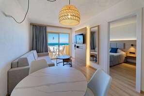 A modern hotel room with a balcony, a dining area, and a living space. - Servatur Caribe (Adeje)