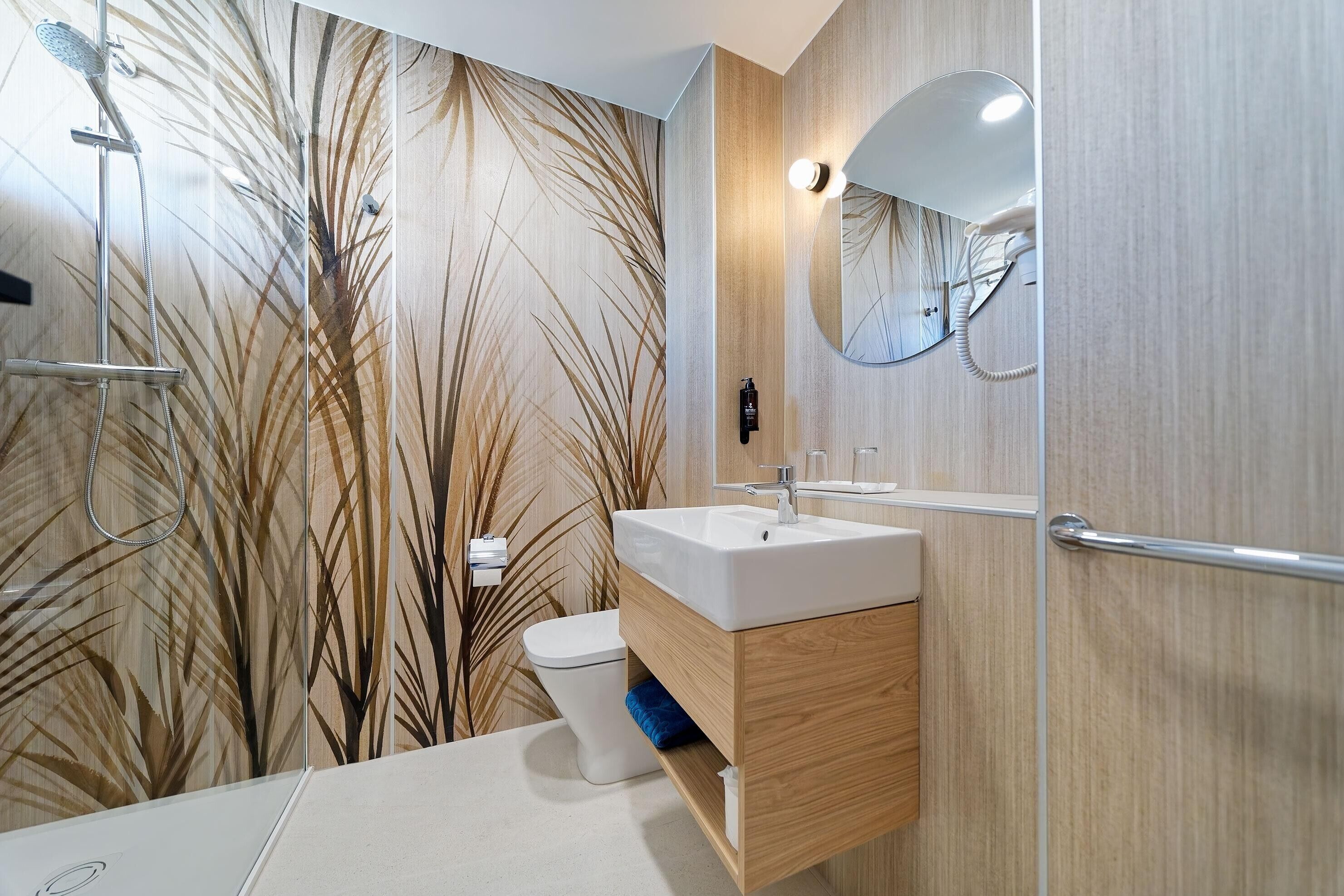 A modern bathroom with a shower, toilet, and sink.