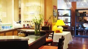 A restaurant with a bar area, wooden flooring, and a yellow lamp.