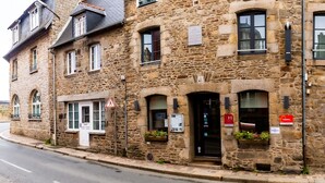 Un bâtiment en pierre avec une enseigne indiquant « Inter Hotel » et une entrée bien visible.