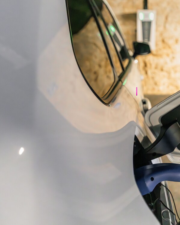 A close-up of a vehicle's side mirror and part of the door handle.