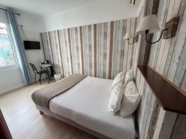 Un dormitorio con cama, escritorio y silla.