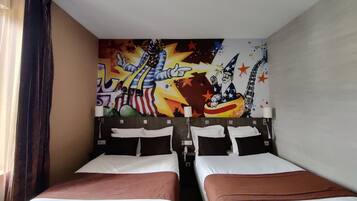 Een hotelkamer met twee bedden, een kleurrijke muurschildering en een raam met gordijnen.