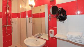 A bathroom with a shower, sink, and mirror.