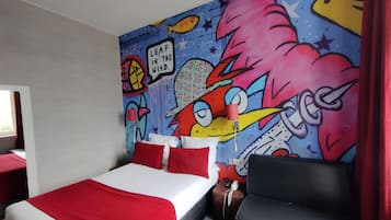 Hotelkamer met een bed, een kleurenschema in rood en wit, een muurschildering en een rood gordijn.
