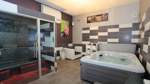 A modern bathroom with a glass-enclosed shower, a large bathtub, and a seating area.