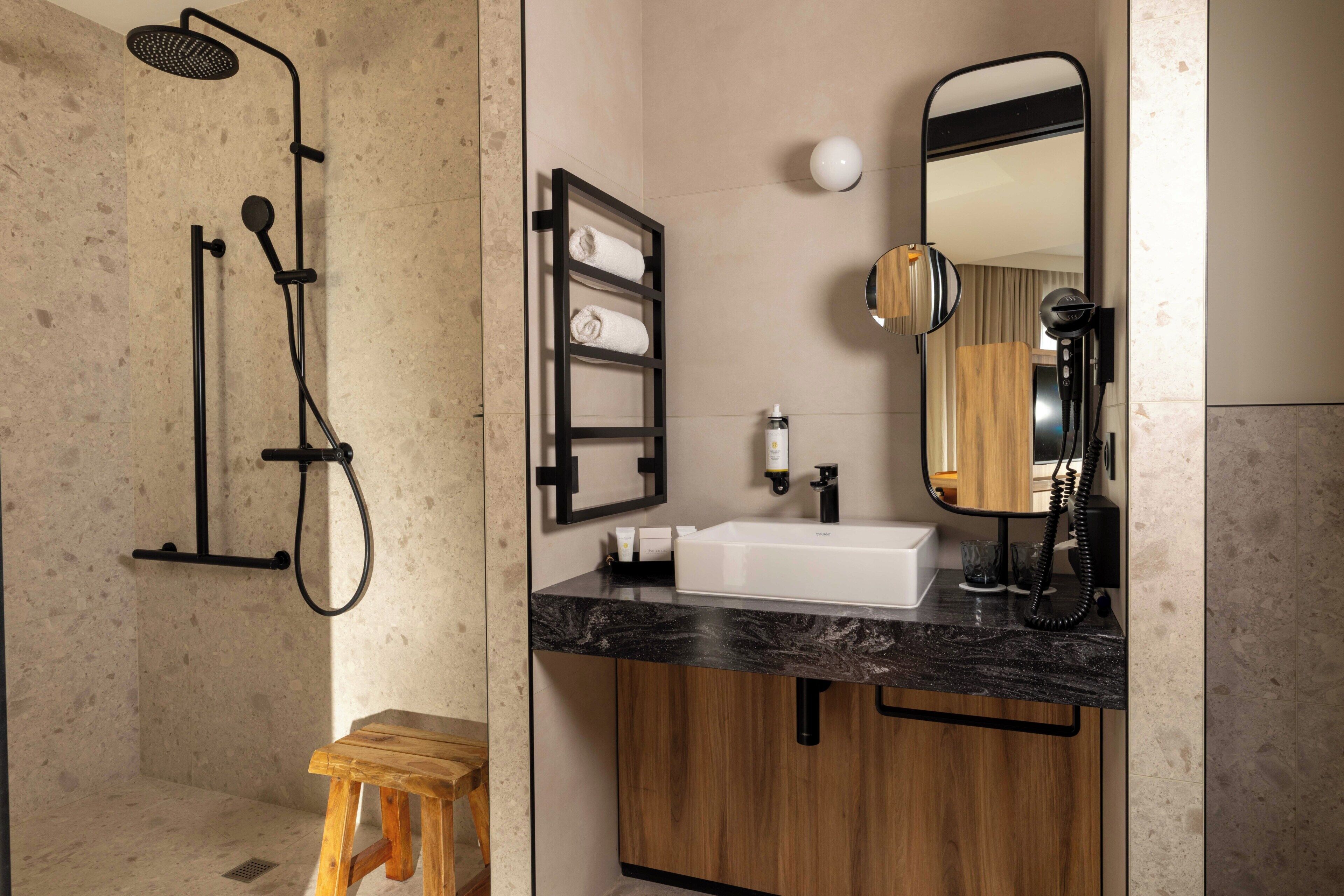 A modern bathroom with a shower, vanity, and wooden cabinets.