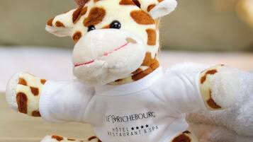 A plush giraffe toy wearing a white shirt with text.