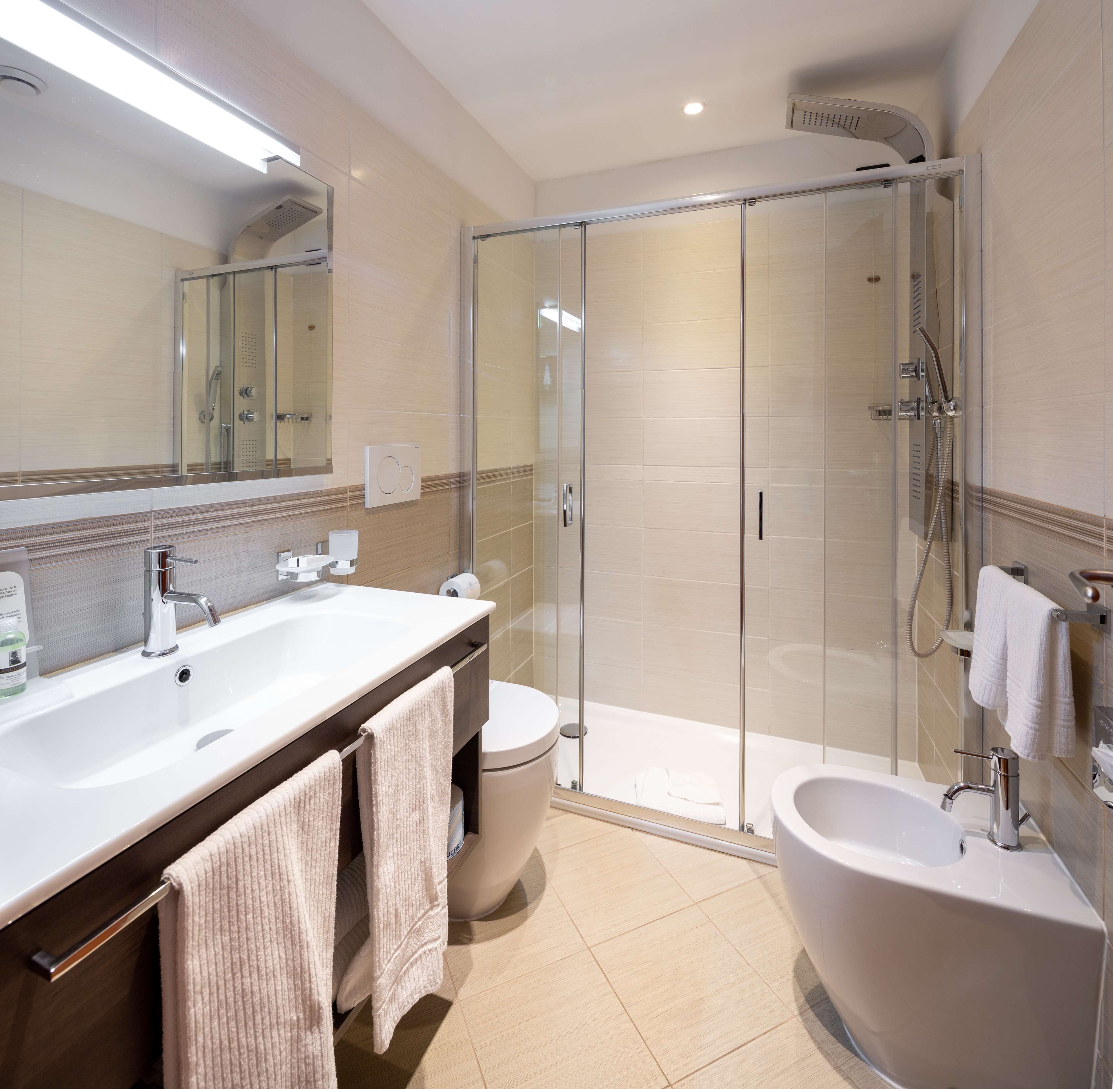 Uma casa de banho moderna com chuveiro em cabine de vidro, uma banheira grande e uma pia dupla.