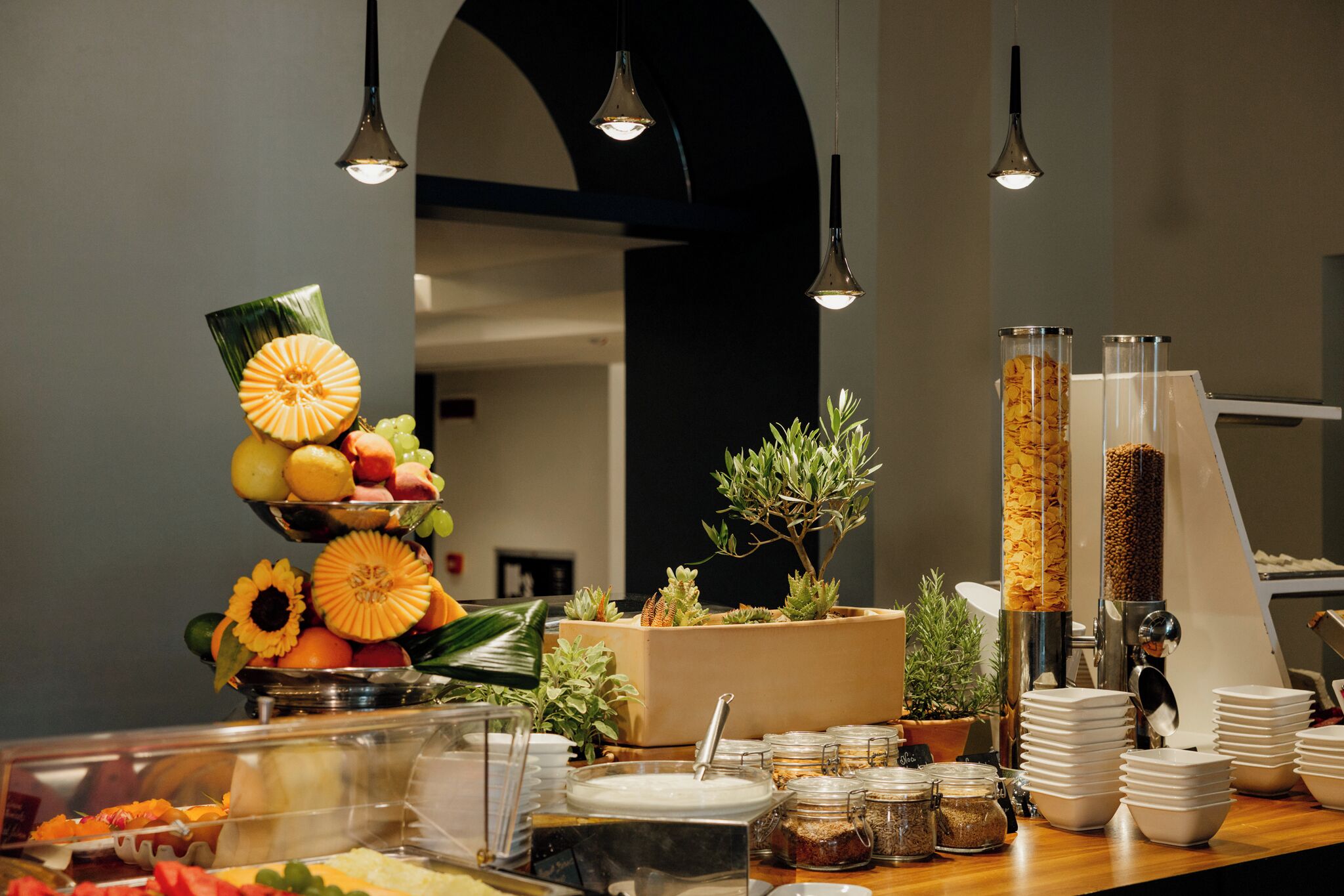 Un'area buffet con diversi cibi, tra cui frutta e cereali, e una macchina per il caffè.