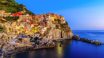 Un pueblo costero con edificios coloridos encaramado a un acantilado con vistas al mar.