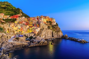 Un pueblo costero con edificios coloridos encaramado a un acantilado con vistas al mar.