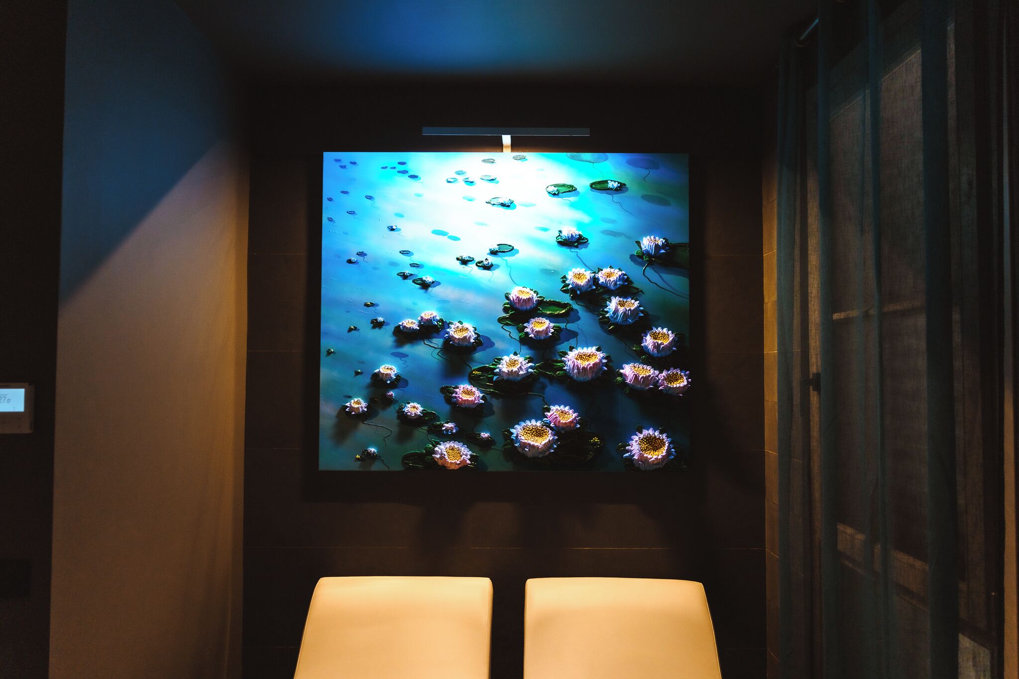 A wall-mounted artwork of water lilies and lotus flowers.
