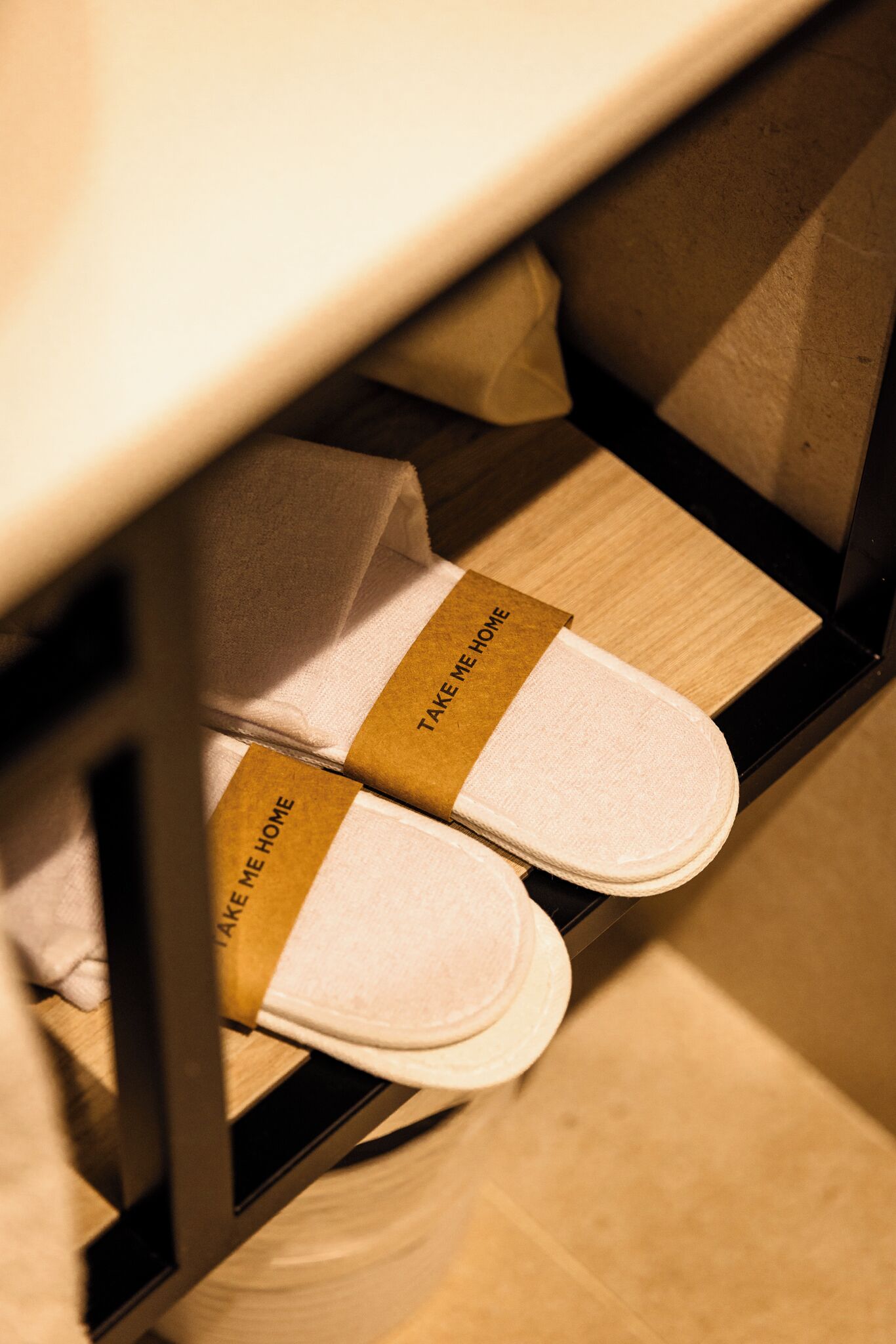 Une paire de chaussons posée sur une étagère, avec une étiquette.