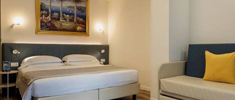 A bedroom with a bed, bedside tables, a painting, a sofa, and a nightstand.