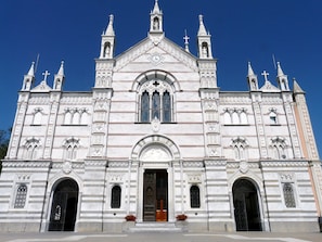 Una iglesia grande y ornamentada con una cúpula central, múltiples agujas y una entrada destacada con una puerta de madera.