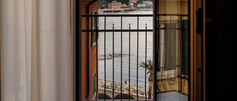 Un balcón con vista a un cuerpo de agua y edificios a lo lejos.