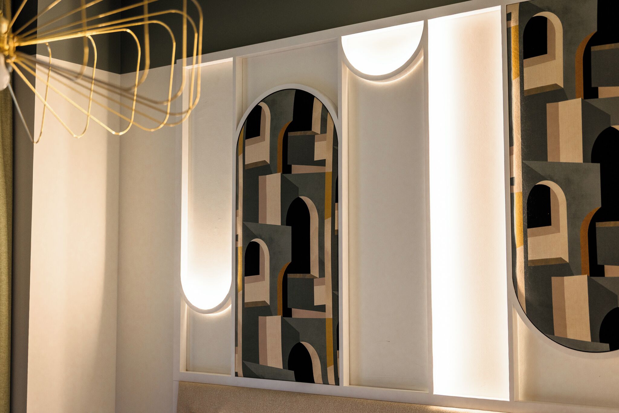 A modern interior with geometric wall designs, recessed lighting, and a decorative ceiling light fixture.