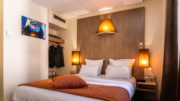 Een hotelkamer met een groot bed, twee nachtkastjes, een garderobe en een schilderij aan de muur.