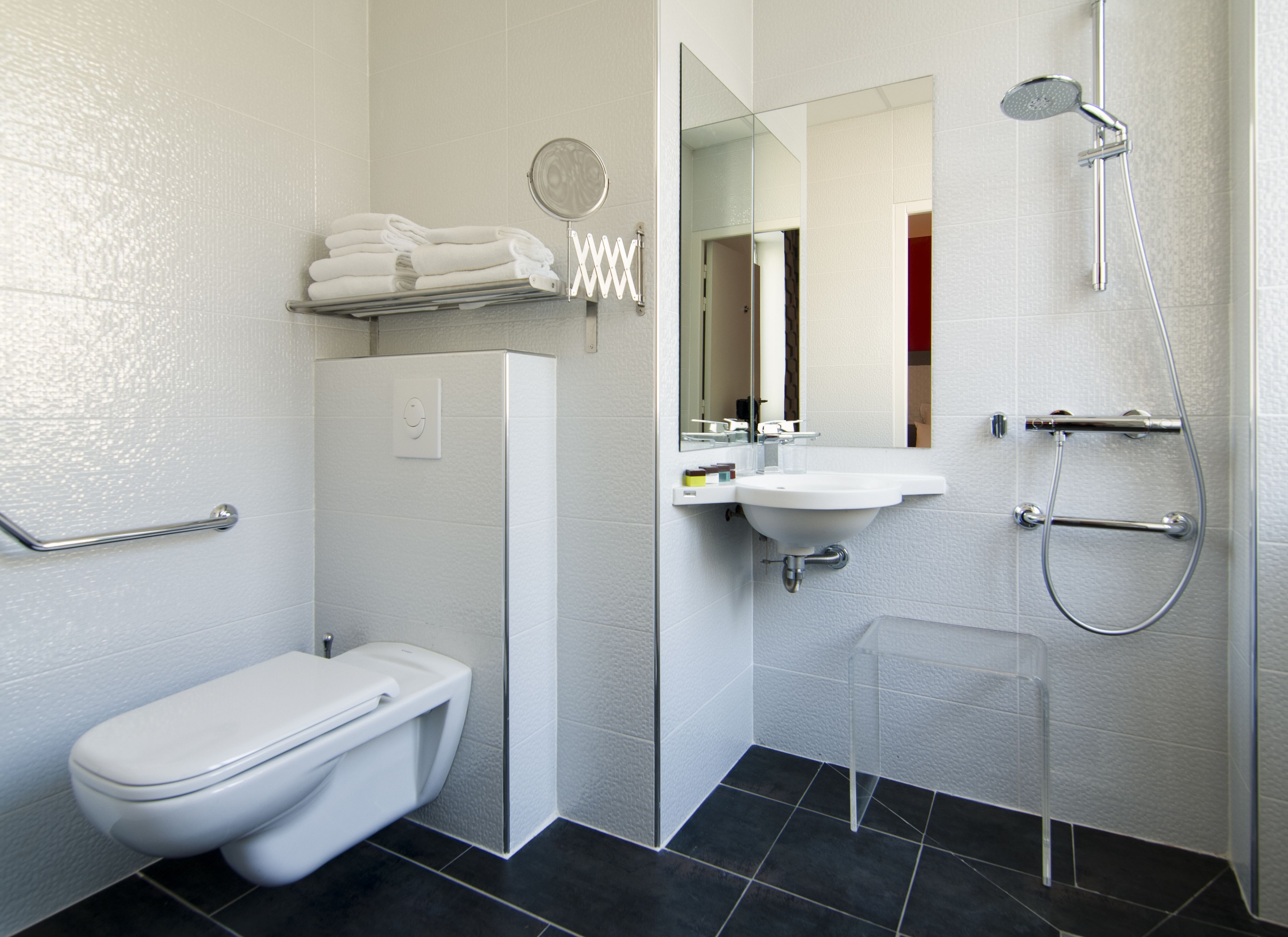 Ein modernes Badezimmer mit Toilette, Waschbecken und Dusche.