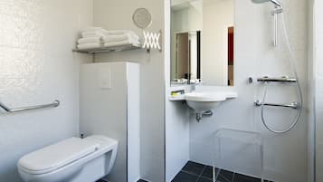 Ein modernes Badezimmer mit Toilette, Waschbecken und Dusche.